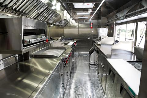 Example of a proper mobile food set up including a fully enclosed space, hand-washing sink, and proper heating and cooling areas