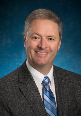 Randy Evetts, smiling and wearing a blue stripped tie.